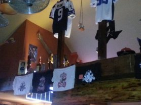A combination of Dallas Cowboys paraphenalia and trophys decorate the indoor beams.